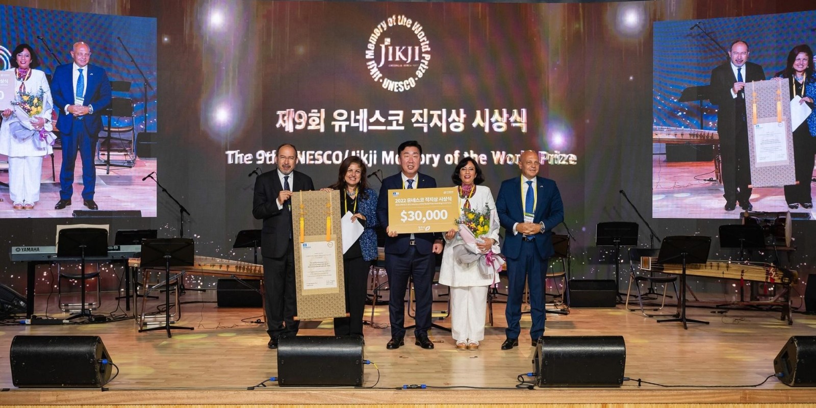 Group of people receiving award on stage