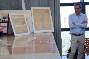 A man standing with crossed hands beside his architecture project