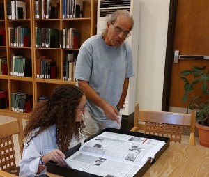 a faculty member with a student reviewing historical publications
