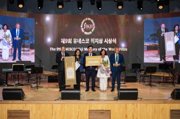 Group of people receiving award on stage